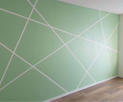 een wand in een slaapkamer is lichtgroen geschilderd door schuit schilderwerken